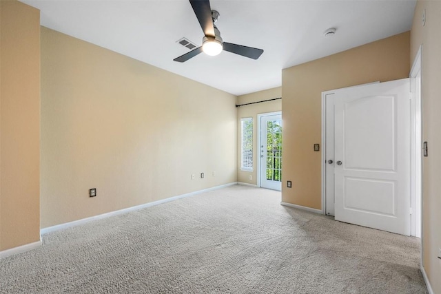 spare room with visible vents, carpet floors, baseboards, and ceiling fan