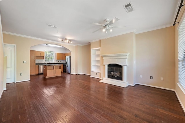 11203 Ranch Road 2222 1105, Austin, TX 78730 - unfurnished living room featuring a ceiling fan, dark wood-type flooring, arched walkways, a fireplace with raised hearth, and ornamental molding