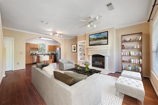 11203 Ranch Road 2222 1105, Austin, TX 78730 - living area featuring a glass covered fireplace, arched walkways, dark wood finished floors, built in features, and crown molding