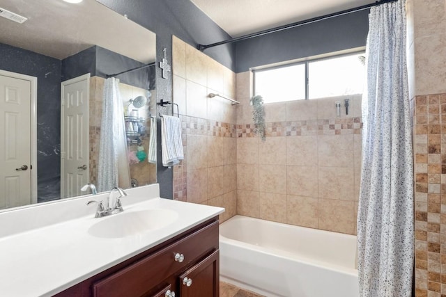 bathroom with shower / tub combo with curtain, vanity, and visible vents