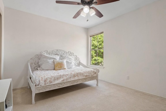 bedroom featuring light carpet and a ceiling fan