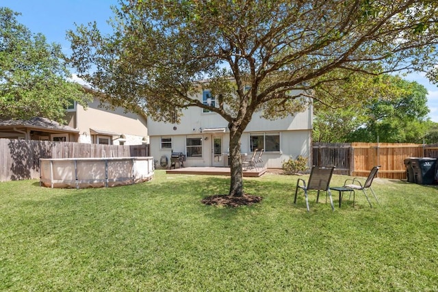 back of house with a fenced in pool, a yard, a deck, and a fenced backyard