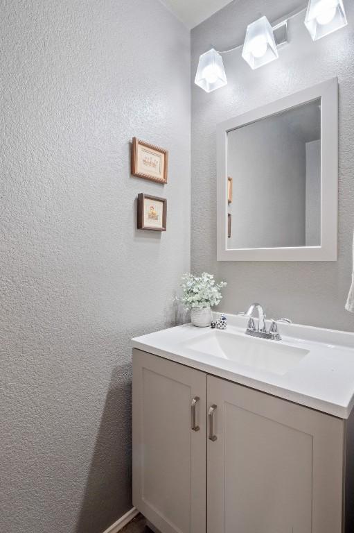 bathroom featuring a textured wall and vanity
