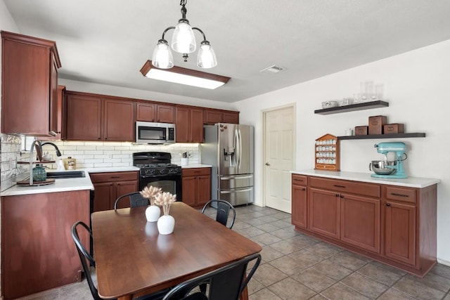 kitchen featuring open shelves, light countertops, a sink, stainless steel appliances, and backsplash
