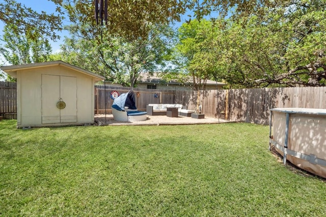 view of yard with an outbuilding, a fenced backyard, an outdoor hangout area, and a storage unit
