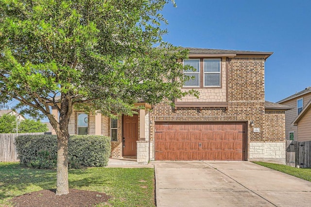 view of front of property with a front yard, an attached garage, fence, concrete driveway, and brick siding