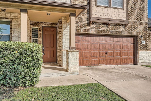 1161 Verna Brooks Way, Kyle, TX 78640 - doorway to property featuring brick siding, a garage, driveway, and stone siding