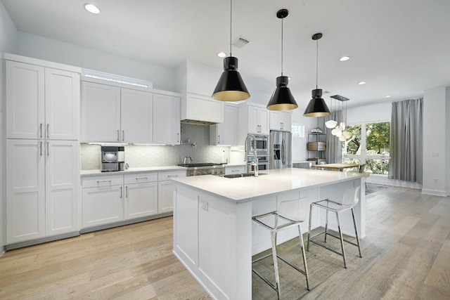 903 W Gibson St, Austin, TX 78704 - kitchen featuring stainless steel appliances, backsplash, recessed lighting, white cabinets, and light wood-type flooring