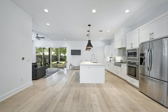 903 W Gibson St, Austin, TX 78704 - kitchen featuring stainless steel appliances, open floor plan, a sink, white cabinets, and recessed lighting
