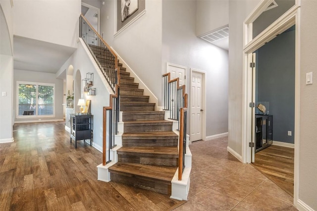 1218 Swenson Farms Blvd, Pflugerville, TX 78660 - stairway featuring a high ceiling, wood finished floors, and baseboards