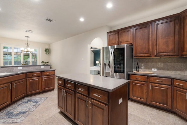 1218 Swenson Farms Blvd, Pflugerville, TX 78660 - kitchen featuring stainless steel refrigerator with ice dispenser, arched walkways, a chandelier, light tile patterned floors, and tasteful backsplash