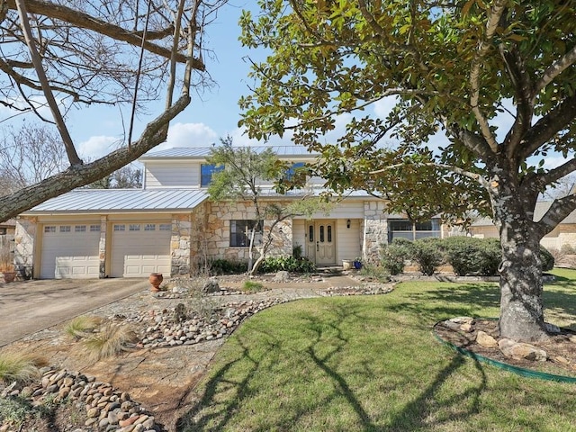 view of front of property featuring a front yard, a garage, metal roof, stone siding, and concrete driveway