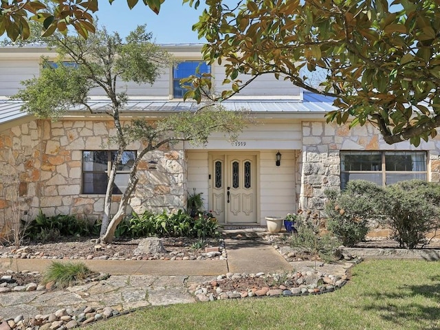 view of front facade featuring metal roof and stone siding