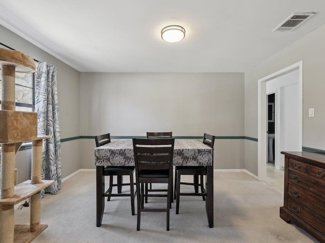 dining room featuring visible vents, baseboards, and light carpet