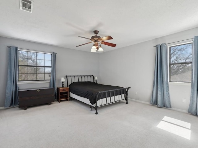 carpeted bedroom featuring visible vents, a ceiling fan, and baseboards