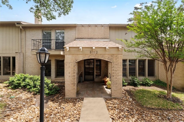 8112 W Ct, Austin, TX 78759 - view of front of property featuring brick siding, a chimney, and a balcony