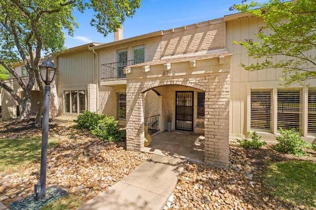 8112 W Ct, Austin, TX 78759 - view of front facade featuring a balcony, brick siding, and a chimney