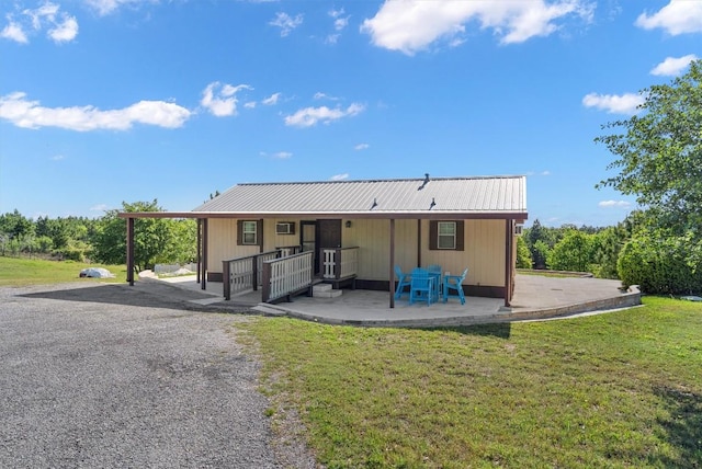 459 Mcallister Rd, Bastrop, TX 78602 - back of house featuring a yard, metal roof, and a patio