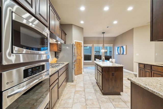 4105 Gandara Bnd, Austin, TX 78738 - kitchen with appliances with stainless steel finishes, hanging light fixtures, a kitchen island, light stone counters, and recessed lighting