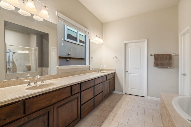bathroom featuring a sink, tile patterned floors, tiled shower, and double vanity
