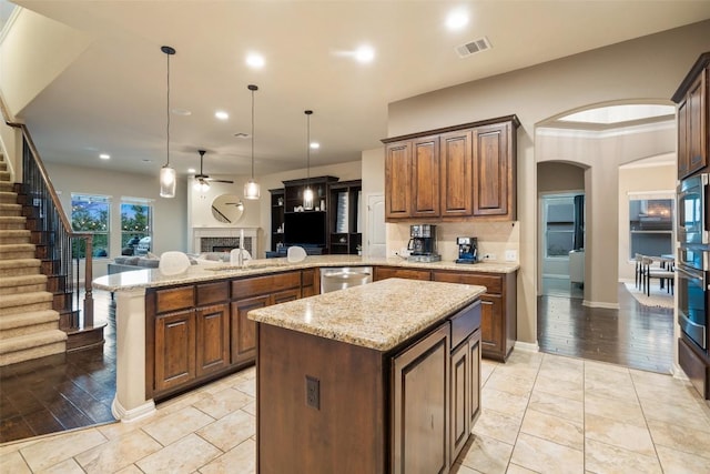 kitchen featuring open floor plan, a peninsula, a ceiling fan, visible vents, and appliances with stainless steel finishes