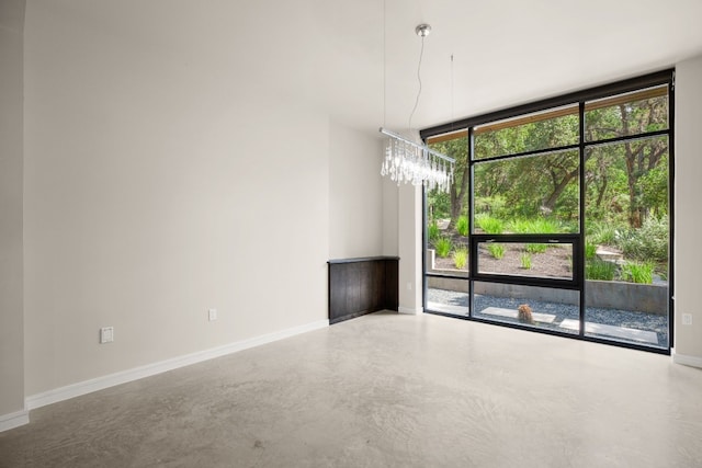 500 Laurel Valley Rd, West Lake Hills, TX 78746 - unfurnished dining area featuring floor to ceiling windows, finished concrete flooring, baseboards, and a chandelier