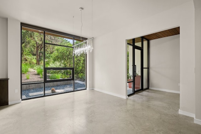 500 Laurel Valley Rd, West Lake Hills, TX 78746 - empty room with concrete floors, baseboards, a chandelier, and expansive windows