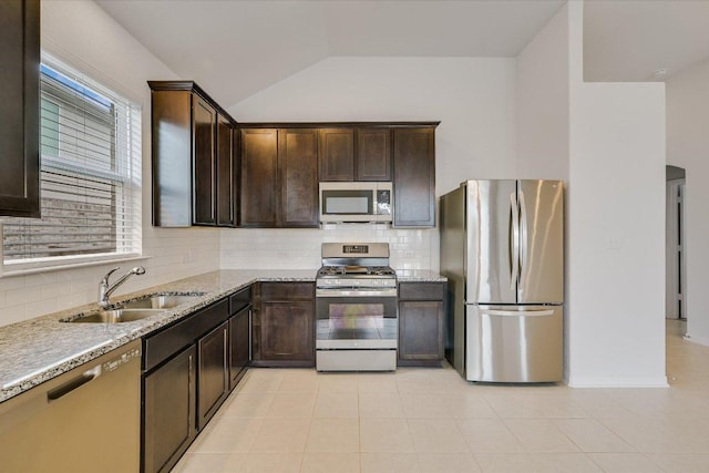 136 Gamble St, Buda, TX 78610 - kitchen with stainless steel appliances, dark brown cabinets, decorative backsplash, lofted ceiling, and light tile patterned floors