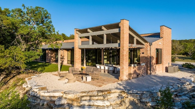 115 Seale Hill Rd, Comfort, TX 78013 - rear view of house with a patio area, outdoor lounge area, a chimney, a metal roof, and a yard