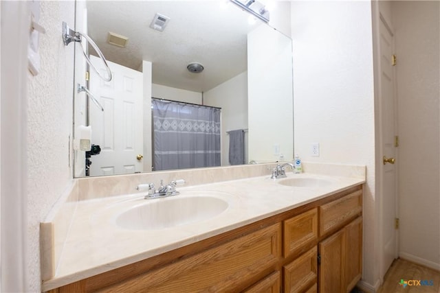 bathroom featuring a sink, visible vents, double vanity, and curtained shower