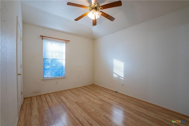 spare room with baseboards, a ceiling fan, and wood finished floors