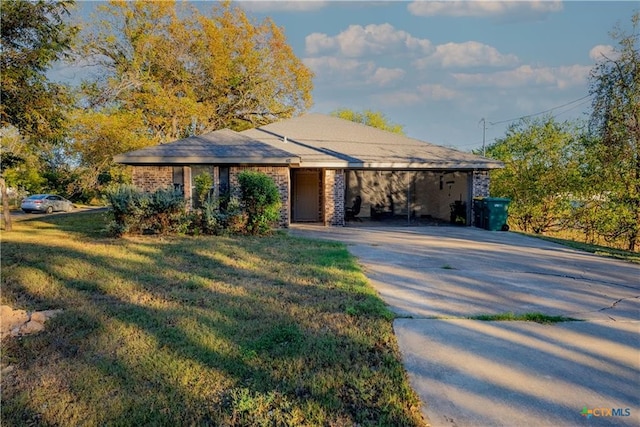 view of front facade featuring a carport, a front yard, and concrete driveway