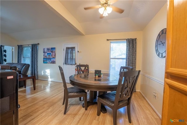 dining area with light wood-type flooring, baseboards, a ceiling fan, and vaulted ceiling
