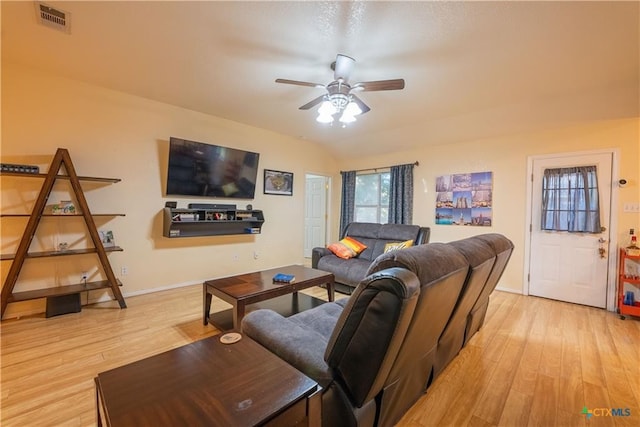 living area featuring visible vents, light wood-style flooring, a ceiling fan, and baseboards