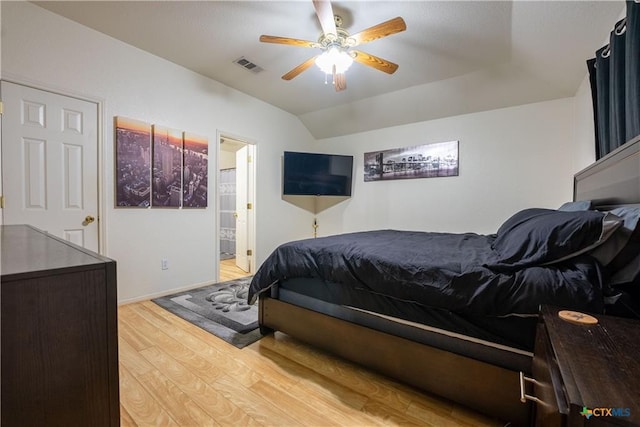bedroom featuring light wood finished floors, visible vents, a ceiling fan, and connected bathroom