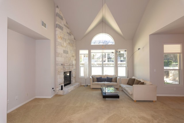 living area featuring light carpet, baseboards, visible vents, high vaulted ceiling, and a fireplace