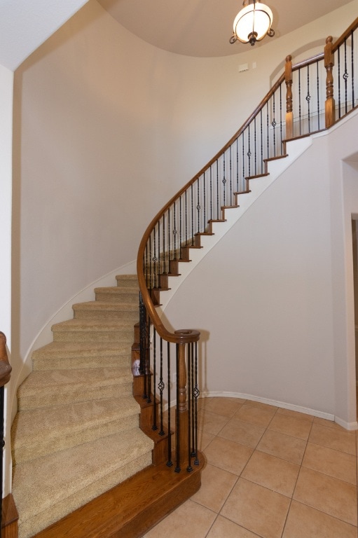 171 Brighton Ln, Austin, TX 78737 - stairs featuring tile patterned flooring and a towering ceiling