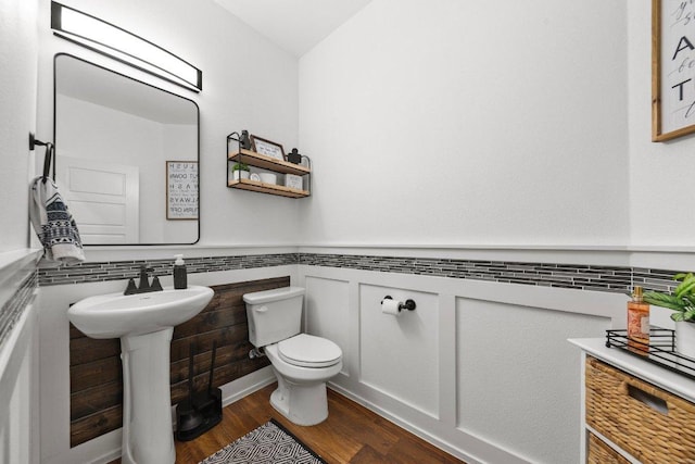 213 Pecan Meadow Ln, Harker Heights, TX 76513 - half bathroom with toilet, wood finished floors, a sink, and wainscoting