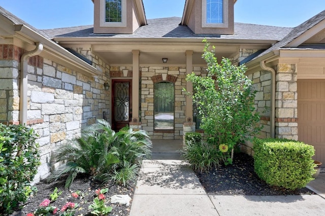 entrance to property with a porch, a shingled roof, and stone siding