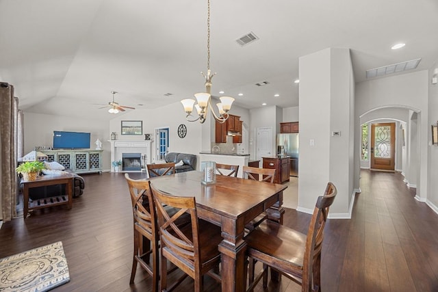 dining room featuring visible vents, dark wood-style floors, arched walkways, and ceiling fan with notable chandelier