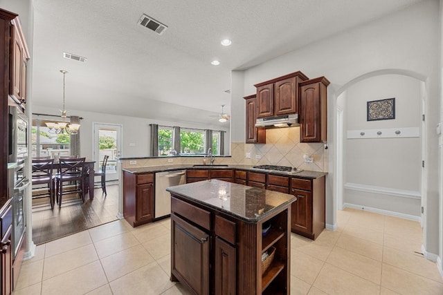 kitchen featuring stainless steel appliances, under cabinet range hood, a peninsula, and visible vents