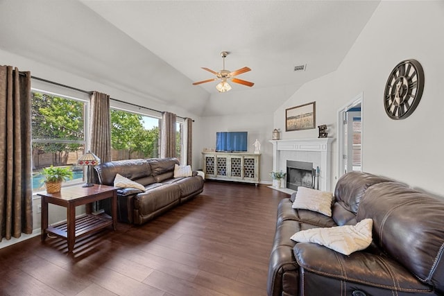 living room with visible vents, a tiled fireplace, ceiling fan, dark wood-style floors, and lofted ceiling