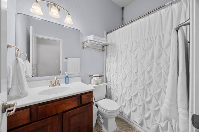 bathroom featuring toilet, a shower with shower curtain, and vanity