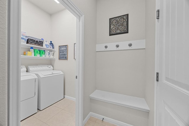 washroom with washer and dryer, light tile patterned flooring, and laundry area