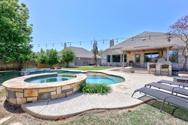 view of swimming pool featuring a patio area, a fenced backyard, outdoor dry bar, an in ground hot tub, and a fenced in pool