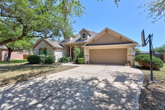 view of front of property featuring concrete driveway, stone siding, an attached garage, fence, and a shingled roof