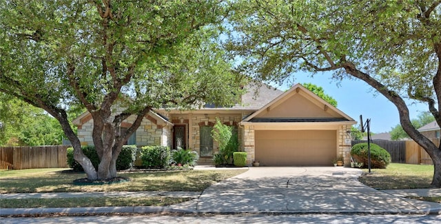 ranch-style home with an attached garage, fence, stone siding, and driveway