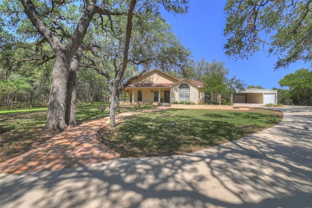 view of front facade featuring covered porch, concrete driveway, a front lawn, and stone siding