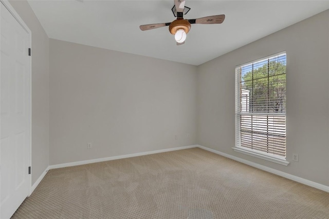 spare room with ceiling fan, carpet floors, and baseboards