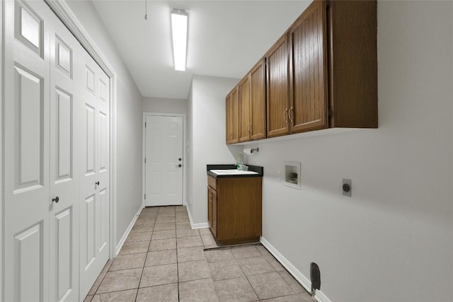 clothes washing area with electric dryer hookup, light tile patterned floors, cabinet space, washer hookup, and baseboards